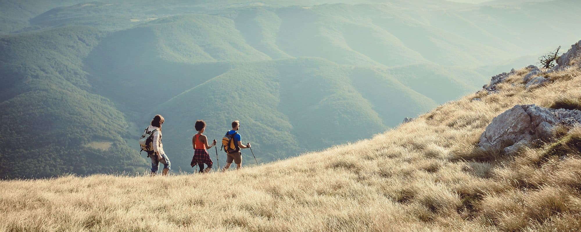 three people hiking on a mountain