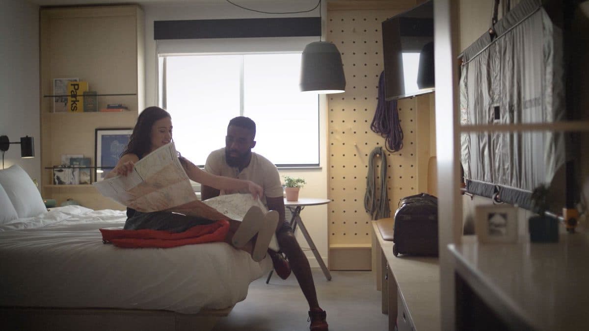 a couple looking sitting on a bed looking at a map