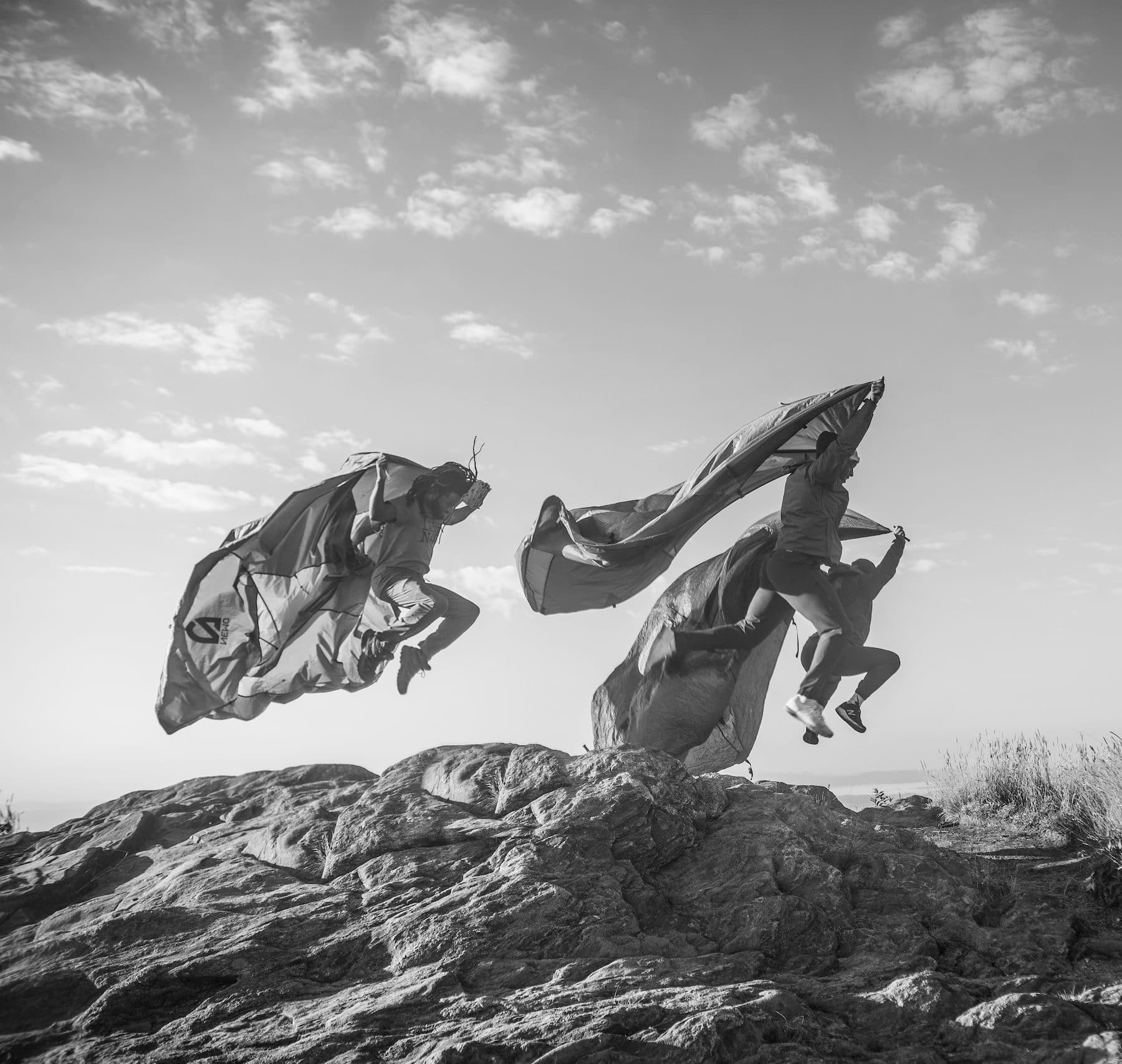people jumping in the air holding sheets