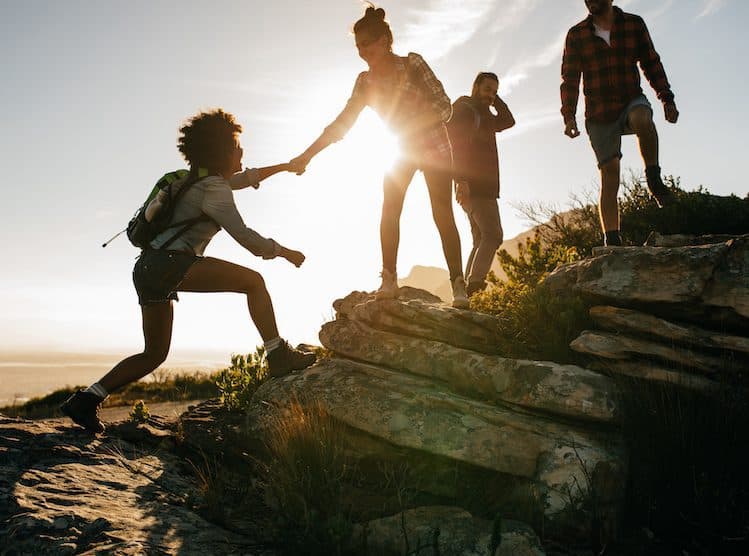 A woman holding out a hand to another hiker