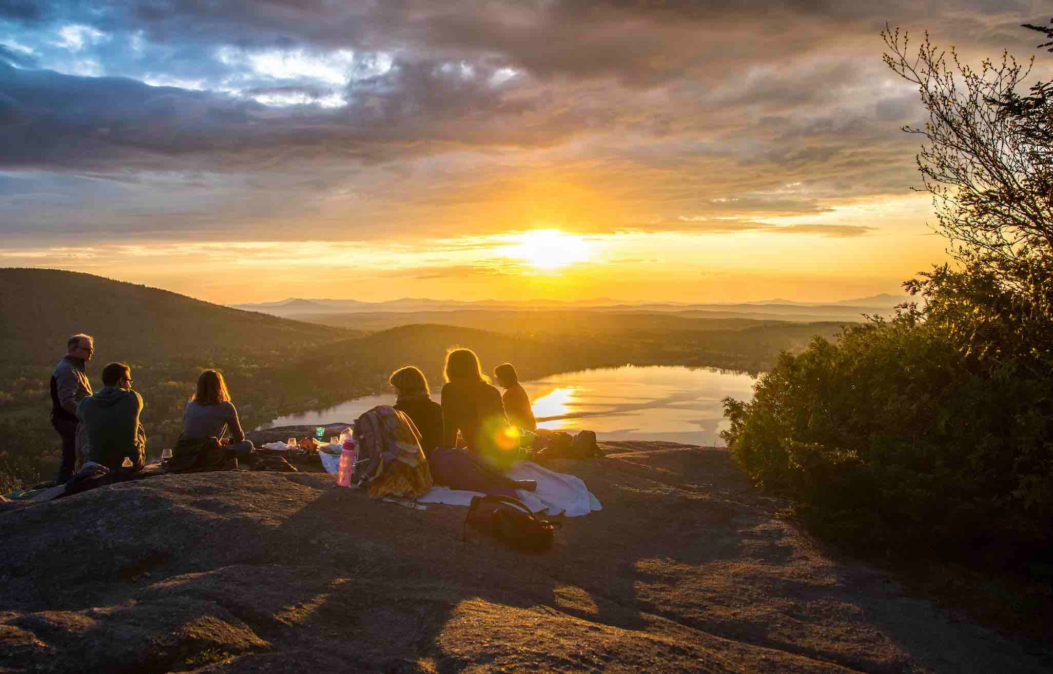 A group having a picnic at a viewpoint at sunset