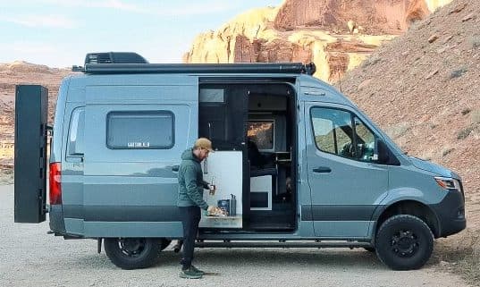 person standing by travel van