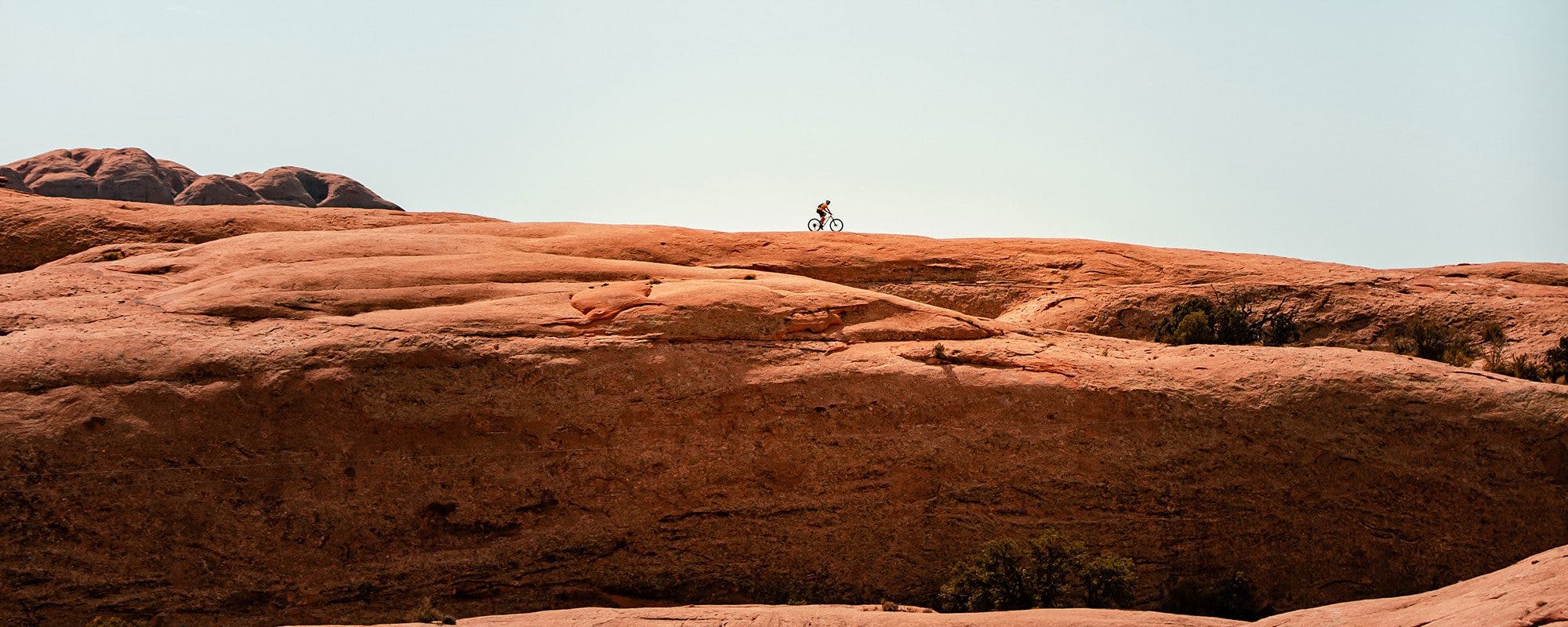 person riding a bicycle along a canyon