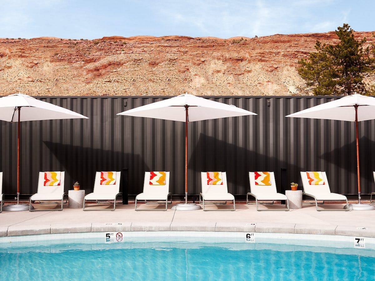 A pool area with seating and a parasol