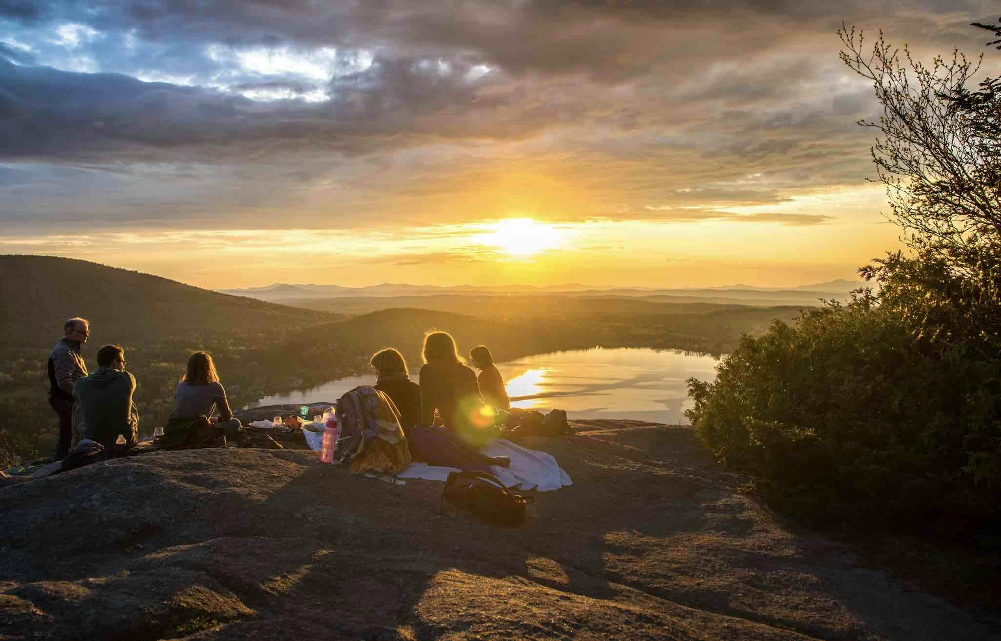 A group having a picnic at a viewpoint at sunset